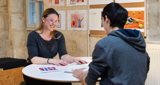 Photo d'un entretien d'admission à l'ECV, un futur étudiant en train de présenter son portfolio à l'examinatrice